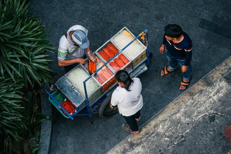 A Bangkok street-food stall with a cook working over the burners
