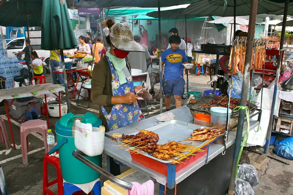 Bagged Thai snacks with handwritten prices at a Bangkok market