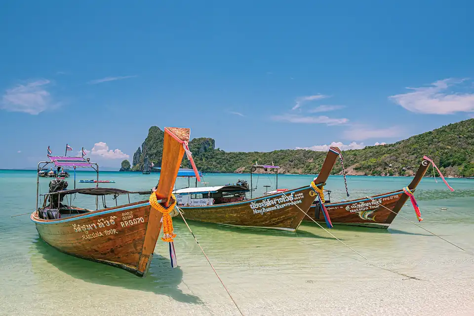 A longtail boat moored off a limestone island in southern Thailand