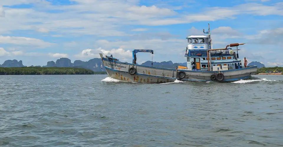 A working boat on Phang Nga bay with the karst skyline behind