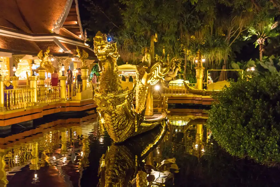 A gilded pavilion over the water at night