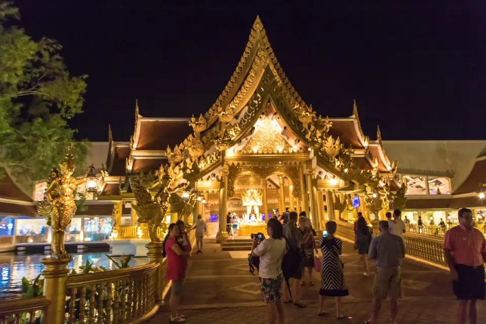 Visitors at a temple-style gate at night