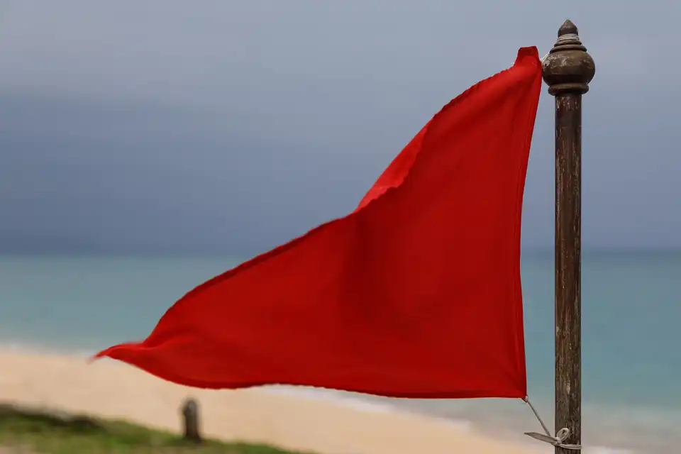 A red flag flying on Mai Khao beach