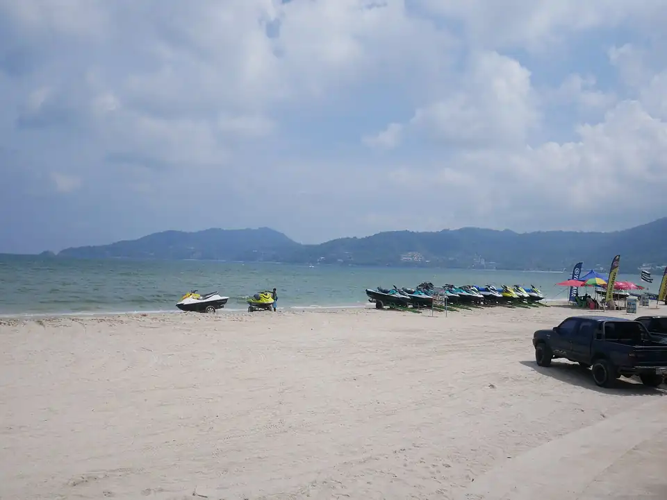 Jet-skis lined up on Patong with the hills across the bay