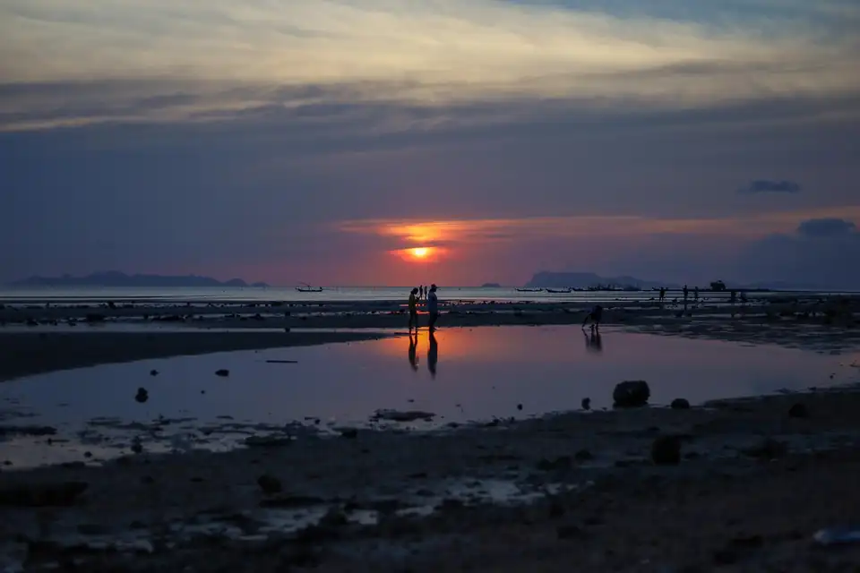 Low sun over exposed tidal flats with distant islands offshore