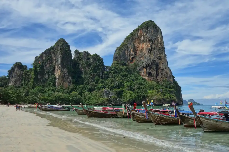 Longtail boats below the limestone karst at Railay West, Krabi
